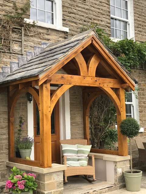 Green oak arched gallows porch handcrafted by The Oak Workshop
